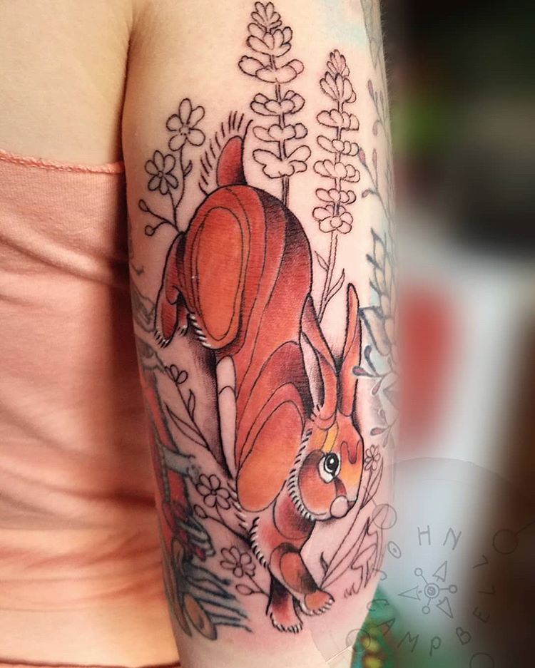 Color Tattoo on Tricep and Upper arm done at Sacred Mandala Studio in Durham, NC of a Rabbit running through Flowers by tattoo artist John Campbell.